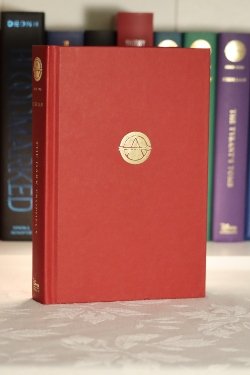 A red hardcover book with a gold symbol in the center with an 'A'.