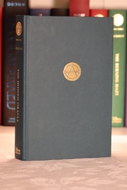 A teal hardcover book with a gold symbol in the center with an 'A'.